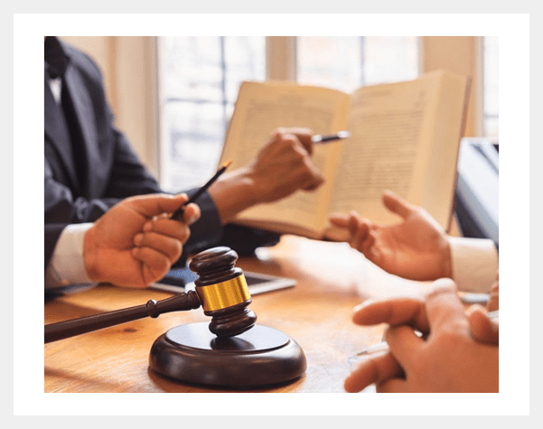 A group of people sitting around a table with papers and a gavel.